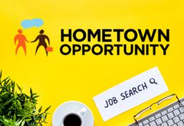 keyboard, cup of coffee, plant on a table with a paper written Job Search and the Hometown Opportunity logo